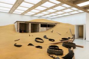 Installation view of Mike Nelson, Triple Bluff Canyon (the woodshed), 2004. Various materials. M25, 2023. Found tyres. Photo: Matt Greenwood. Courtesy the artist and the Hayward Gallery.