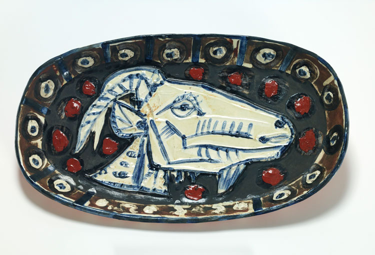 Pablo Picasso, Plate Decorated With a Goat's
Head. Vallauris and Cannes, June 5, 1952 and February 16, 1956. Empreinte originale in fired white clay, painted with slips and enamel, partially glazed. 31.5 x 51.5 x 5 cm. Fundación Almine y Bernard Ruiz-Picasso, Madrid © FABA. Photo: Marc Domage © Succession Pablo Picasso, VEGAP, Madrid, 2025.