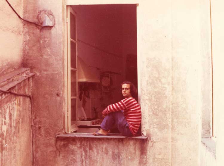Photograph of the artist dressed as a clown at the window of his studio, Genoa, 1968.  Courtesy Archivio Emilio Prini.