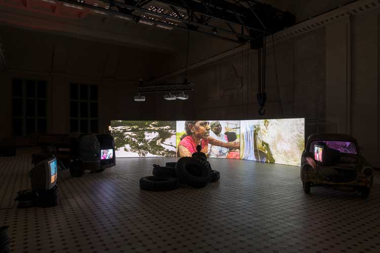 Installation view of The Family (A Zombie Movie) by Karrabing Film Collective, as part of Power Nights curated by Lucia Pietroiusti at E-Werk Luckenwalde, 2021–22. Courtesy: E-WERK Luckenwalde and Karrabing Film Collective. Photo: Stefan Kort.