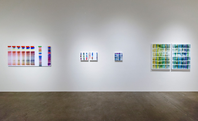 Jaq Chartier: SunTests, installation view, Robischon Gallery 2019. Left to right: Suntest #1 (6 Intervals), dye sublimation on aluminum, 31 x 65 in; 27 Formulas, acrylic, ink, dyes, stains and spray paint on panel, 12 x 12 in; Small Study (July), acrylic, ink, dyes, stains and spray paint on panel 12 x 12 in; 22 Tests and 4 Whites, acrylic, ink, dyes, stains and spray paint on panel, 12 x 12 in; Green/Blue Chart, acrylic, ink, dyes, stains and spray paint on panel, 40 x 61 in. Image courtesy Robischon Gallery.