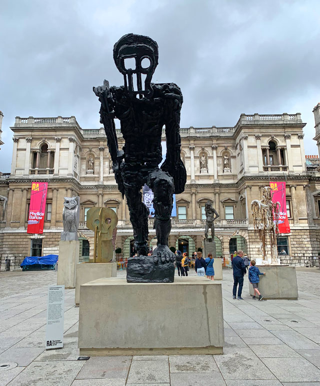 Foreground: Thomas Houseago, Large Walking Figure I (Leeds). Bronze, 476 x 201 x 274 cm. Installation view, Royal Academy of Arts courtyard. Photo: Martin Kennedy.