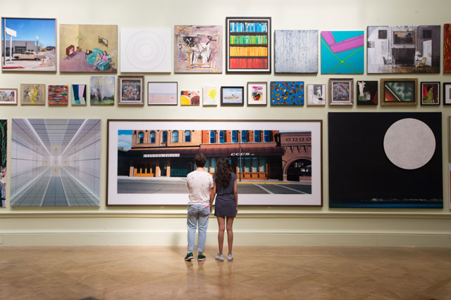 Installation view of Gallery III hung by Jock Mcfadden. Large photo in centre is Wim Wenders, Street Front in Butte, Montana. Photo: © David Parry/ Royal Academy of Arts.