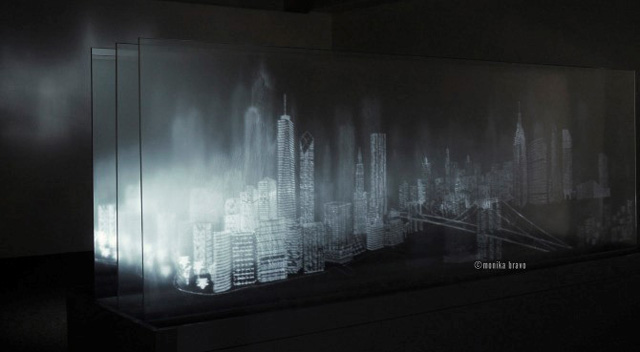 Monika Bravo, Landscape of Belief, 2012. Glass, mirror, projector, media player, aluminum, wood, text from Italo Calvino’s Invisible Cities, time-based electronic installation. Courtesy of the artist and Johannes Vogt Gallery.