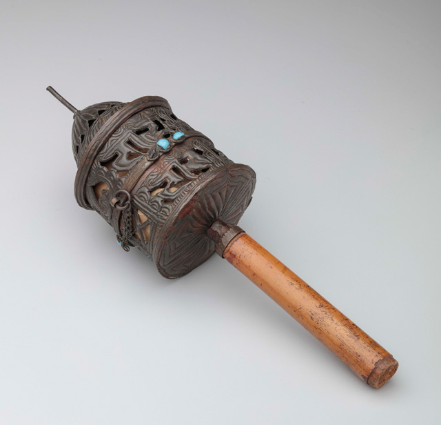Pierced handheld prayer wheel (mani lag ‘khor), Tibet, before 1927. Copper alloy, steel, glass, ink, paper, bamboo. Newark Museum; Gift of Mrs. J. B. Barlow. Photo © Newark Museum.