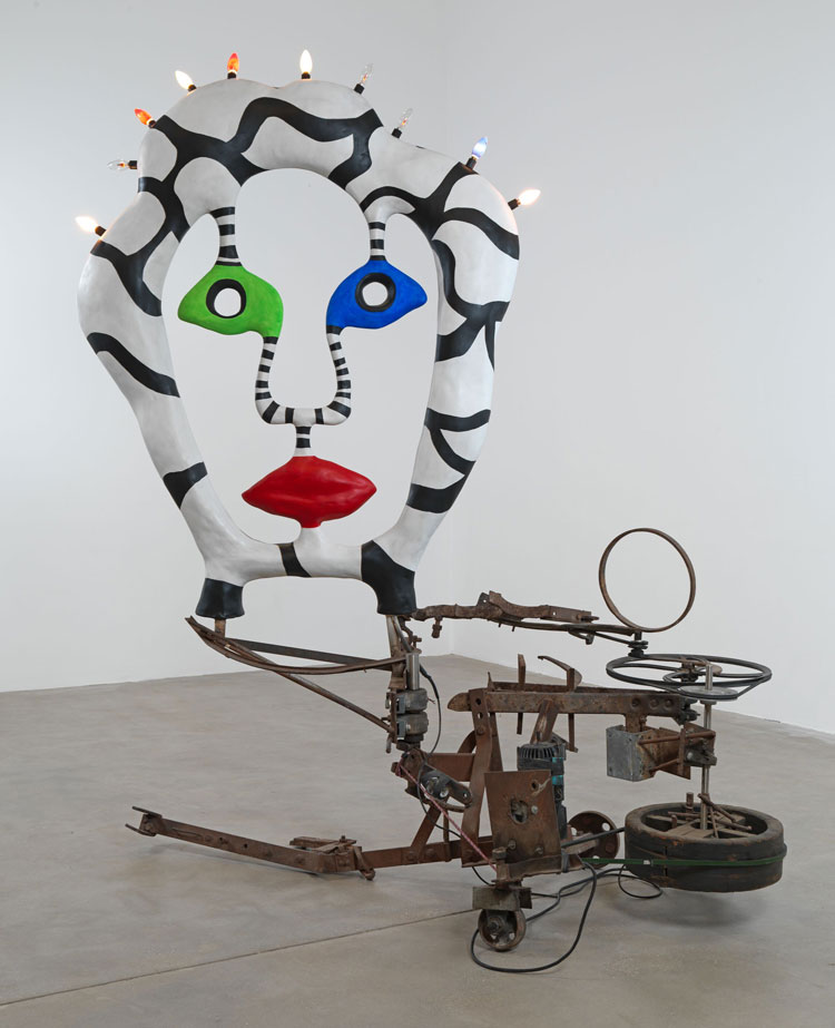 Niki de Saint Phalle, La Grande Tête, 1988. Iron, wood, electric motor, bungee, lightbulbs, polyester head, 225 x 225 x 140 cm (88 5/8 x 88 5/8 x 55 1/8 in). Installation view, Hauser & Wirth Somerset, 2025. © Niki Charitable Art Foundation. All Rights Reserved, DACS 2025. © Jean Tinguely, DACS 2025. Photo: Ken Adlard. Courtesy the artists and Hauser & Wirth.