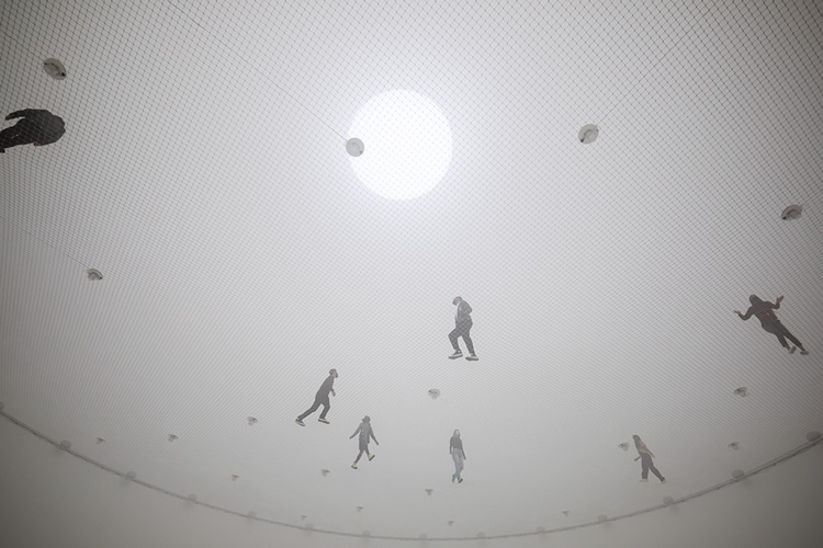 Tomás Saraceno, Free the Air: How to hear the universe in a spider/web, 2022. Custom steel, wire net, wood, light, LFE, shakers, fog. Diameter: 95 feet. Artwork © Studio Tomás Saraceno. Commissioned by The Shed. Photo: Nicholas Knight. Courtesy the artist and Tanya Bonakdar Gallery, New York/Los Angeles; Neugerriemschneider, Berlin; Andersen’s, Copenhagen; Ruth Benzacar, Buenos Aires; and Pinksummer Contemporary Art, Genoa. Photo courtesy The Shed.