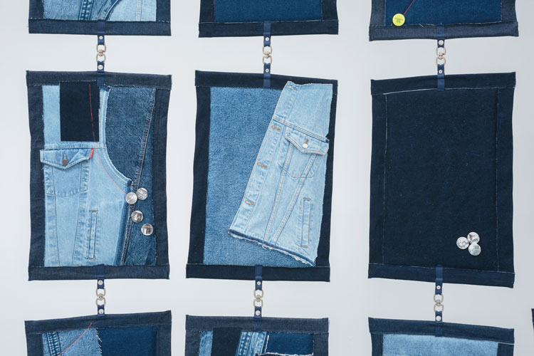 Emma Wolf-Haugh. Domestic Optimism - Soft Furnishings, 2019. Modular Block Screen after Eileen Gray, 15 fabricated panels: second hand denim jackets, screen printed blue denim, embroidery, badges, acrylic paint, snap buttons, chrome fittings. Installation view, Dundee Contemporary Arts, 2019. Photo: Ruth Clark.