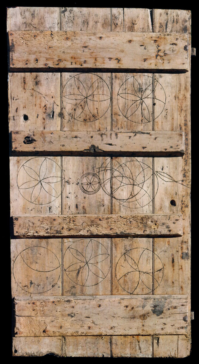 Oak calf-shed door marked with magical symbols to protect livestock. From Laxfield, Suffolk, 19th century, 183 x 94 cm. Private collection.
