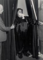 Helen Duncan emerging from curtains with ‘ectoplasm’ – her hands holding those of others
at the séance, Edinburgh, 1933. Photograph © Senate House Library, University of London.