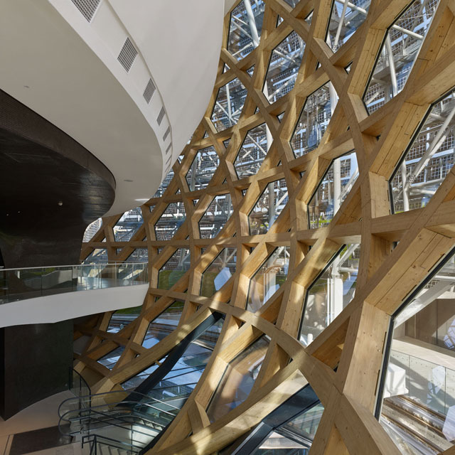 The staircase up into the acoustic auditorium reveals the timber structure, which carries the whole glass façade of the auditorium on a surface of 5,600 sqm. The structure was designed in collaboration with Hermann Blumer. Photograph: Didier Boy de la Tour.