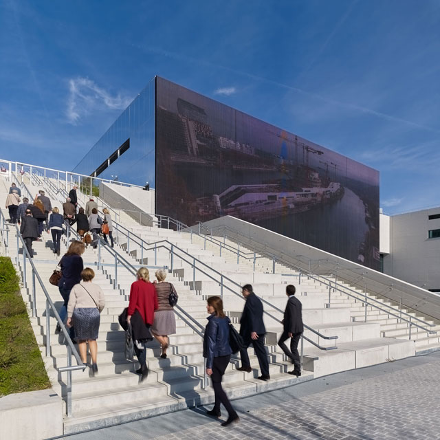 A wide concrete staircase invites the public up and over the building towards the roof garden. Photograph: Didier Boy de la Tour.