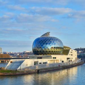 Shigeru Ban’s design for La Seine Musical kept costs down with the same creamy concrete exterior and interior, but there is one extravagance: the acoustic Auditorium with its moveable sail. Photograph: Didier Boy de la Tour.