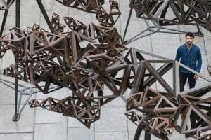 Conrad Shawcross stands in front of The Dappled Light of the Sun in the RA’s Annenberg Courtyard, 2015 © Royal Academy of Arts, Benedict Johnson.