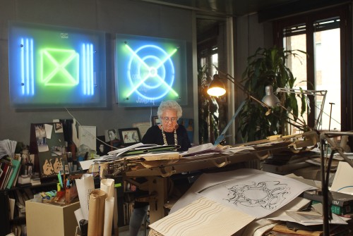 Nanda Vigo in her studio; in the background her work: BASE + LINE, 2003. Photograph © Roswitha Pross, Munich.