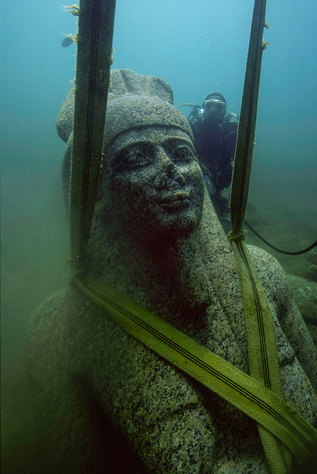 Colossal statue of Hapy. Pink granite. H. 540 cm. IVth century BC. Thonis- Heracleion. Maritime Museum, Alexandria (SCA 281). An expression of great tranquility radiates from the idealized face of this corpulent man with protruding breasts. His headdress bears the bushel of papyrus emblematic for Lower Egypt, particularly associated with Hapy, the divine personification of the Inundation of the Nile. © Franck Goddio/Hilti Foundation. Photograph: Christoph Gerigk.