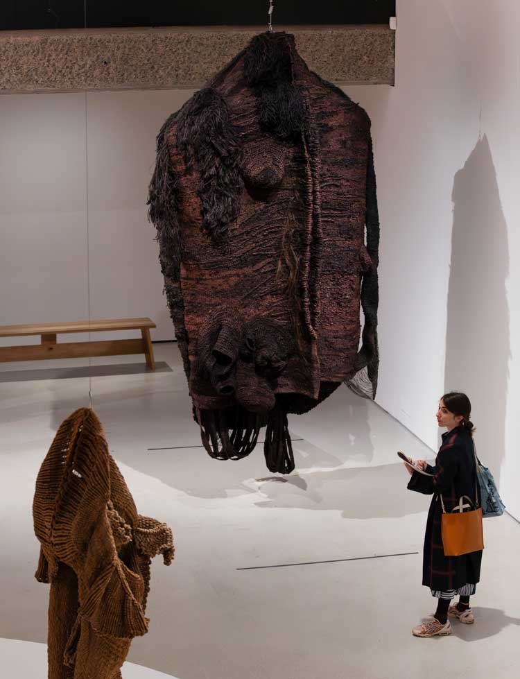 Centre: Magdalena Abakanowicz, Vêtement Noir (Black Garment), 1968. Installation view, Unravel: The Power and Politics of Textiles in Art, Barbican Art Gallery. © Jemima Yong / Barbican Art Gallery.