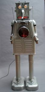 Clayton Bailey. Milker Robot, 1985. Repurposed scrap aluminium, chrome, stainless steel, glass, light bulbs, 67 x 20 x 17 in. Courtesy of the artist. © Clayton Bailey.
