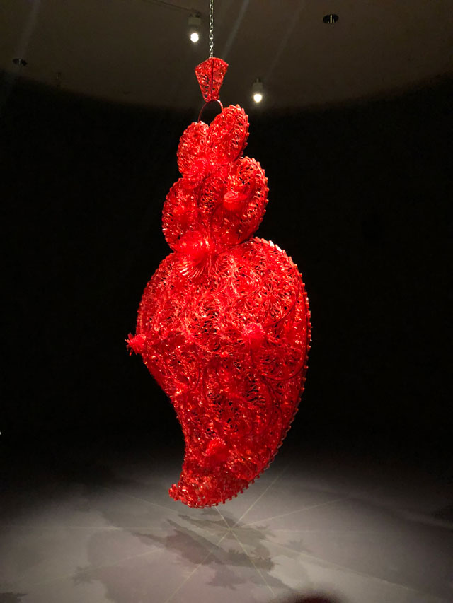 Joana Vasconcelos. Red Independent Heart (Coracao Independente Vermelho), 2005. Translucent plastic cutlery, painted Iron, metal chain, power supply unit, motor, sound Installation, 371 x 220 x 75 cm. Museu Coleccao Berardo. © Joana Vasconcelos, VEGAP, Bilbao, 2018.