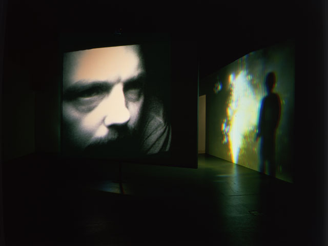 Bill Viola. Slowly Turning Narrative, 1992. Video/sound installation. Central rotating screen, mirrored on one side; two channels of video projections at opposite ends of space, one colour, one black and white, in large, dark room; amplified mono sound, one speaker; amplified mono sound, five speakers, projected image size: 9 x 12 ft (2.75 x 3.65 m); room dimensions: 14 x 20 x 41 ft (4.3 x 6.1 x 12.5 m).
Continuously running.