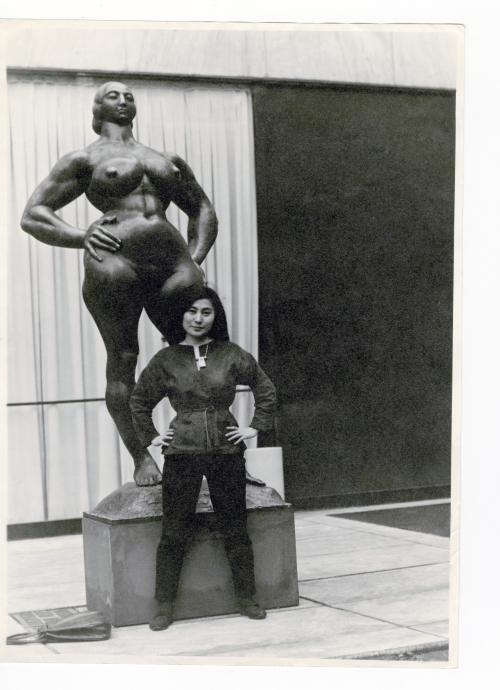 Yoko Ono with Standing Woman (1932) by Gaston Lachaise, The Museum of Modern Art Sculpture Garden, New York, c1960–61. Photograph: Minoru Niizuma. © Minoru Niizuma. Courtesy Lenono Photo Archive, New York.